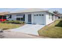 Front view of a single story home with a garage and manicured lawn at 4854 Colonnades Club Blvd, Lakeland, FL 33811