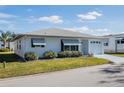 Single story house with a white exterior, garage and well-maintained lawn at 4854 Colonnades Club Blvd, Lakeland, FL 33811