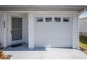 White garage door with windows and a grey front door at 4854 Colonnades Club Blvd, Lakeland, FL 33811