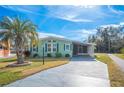 Quaint green home with a palm tree and driveway at 4938 Deerwood Dr, Lakeland, FL 33810