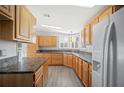 Kitchen with luxury vinyl plank flooring, light wood cabinets, neutral countertops, and stainless appliances at 4938 Deerwood Dr, Lakeland, FL 33810