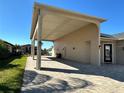 Covered patio area with paver driveway and grassy area at 516 Homecoming Way, Polk City, FL 33868