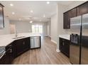 Modern kitchen with dark cabinets, stainless steel appliances, and white counters at 5451 Duxford Cir, St Cloud, FL 34771