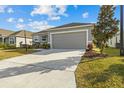 One-story home with gray exterior, two-car garage, and well-manicured lawn at 6046 Eagle Pointe Dr, Lakeland, FL 33812