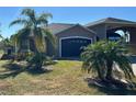 Tan house with palm trees and landscaped yard at 708 Teaberry Trl, Polk City, FL 33868