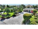 An elevated view of the property surrounded by manicured landscaping and a brick paved driveway at 751 Meandering Way, Polk City, FL 33868