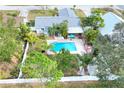 Aerial view showcasing home, pool, and lush landscaping at 813 Heron Pl, Winter Haven, FL 33884