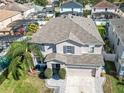 Two-story house, gray roof, and a landscaped yard with palm trees at 1074 Berkeley Dr, Kissimmee, FL 34744