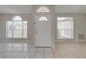 Front entry with tiled floor and two arched windows at 140 Bentley Oaks Blvd, Davenport, FL 33896