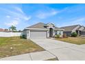 One-story house with gray siding, attached garage, and a well-manicured lawn at 1622 Tressel Ct, Winter Haven, FL 33881