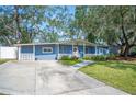 Ranch home with light blue exterior, landscaping, and a long driveway at 1632 Tangerine St, Lakeland, FL 33803