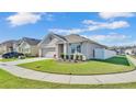 Landscaped home exterior with a well-kept lawn and a white fence, providing privacy and curb appeal at 1878 Pristine Loop, Lakeland, FL 33811