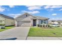 Attractive single-story home with a neat front lawn, showcasing landscaping and an attached two-car garage at 1878 Pristine Loop, Lakeland, FL 33811