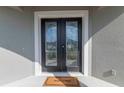 Black double front doors with glass panels and a welcome mat at 1936 Deep Creek Dr, Lakeland, FL 33810