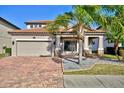 Two-story house with tile roof and paver driveway at 1958 Altavista Cir, Lakeland, FL 33810