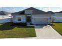 Single-story house with gray exterior, two-car garage, and well-manicured lawn at 252 Walkers Point Dr, Auburndale, FL 33823