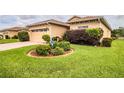 Single-story house with a tan exterior, two-car garage, and landscaped yard at 4128 Aberdeen Ln, Lake Wales, FL 33859