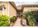 Welcoming front entry with a brick walkway, lush landscaping, and a charming door at 4128 Aberdeen Ln, Lake Wales, FL 33859