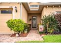 Welcoming front entry with a brick walkway, lush landscaping, and a charming door at 4128 Aberdeen Ln, Lake Wales, FL 33859