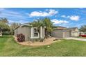 A well-maintained home featuring an inviting yard with stone landscaping and healthy green grass at 4145 Whistlewood Cir, Lakeland, FL 33811