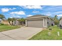 Attractive gray home featuring a two-car garage and a well-maintained lawn at 4145 Whistlewood Cir, Lakeland, FL 33811
