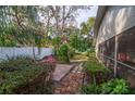 Brick pathway leads to a screened patio and lush garden at 4419 Burlington Dr, Winter Haven, FL 33880