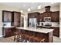 Modern kitchen with dark wood cabinets, granite countertops, and stainless steel appliances at 4434 Micanope Crescent Dr, Lakeland, FL 33811