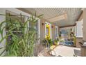 Inviting front porch featuring a corrugated metal ceiling, comfortable seating, and a cheerful yellow door at 531 Hunter St, Lakeland, FL 33803