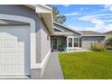 Gray house with white garage door, walkway, and green lawn at 6235 Egret Dr, Lakeland, FL 33809