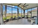 Relaxing screened porch with backyard view, wicker furniture, and ceiling fan at 637 Griffon Ave, Lake Alfred, FL 33850