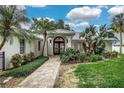 Stunning home exterior featuring a brick walkway, lush landscaping, and a covered entryway with ornate glass doors at 739 Swann Dr, Lakeland, FL 33809
