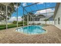 Screened-in pool and spa area with brick pavers, a view of the lake, and plenty of space for entertaining at 739 Swann Dr, Lakeland, FL 33809