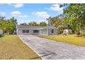 Newly renovated home with gray brick exterior, long driveway, and a spacious yard at 815 N Hendry Ave, Fort Meade, FL 33841