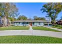 Charming gray house with a welcoming front porch and landscaped yard at 818 Haynes Rd, Lakeland, FL 33809