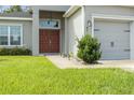 Front entry with red door, walkway, and landscaping at 8218 Wilder Loop, Lakeland, FL 33809