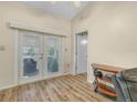 Living room with French doors leading to a sunroom and hardwood floors at 1007 Canary S Cir, Lakeland, FL 33809