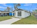 Charming single-story home with white stucco and black trim, featuring a well-maintained front lawn and a modern design at 105 3Rd Eloise St, Winter Haven, FL 33880