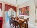 Cozy dining room featuring a wooden table with six chairs and an eye-catching art piece at 205 Terrace Ridge Cir # 205, Davenport, FL 33896