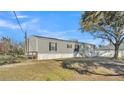 Charming single-story home features gray siding, a fenced yard, and a manicured lawn at 2576 Walker Rd, Lakeland, FL 33810