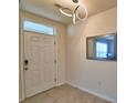 Inviting entryway with modern lighting, a decorative mirror, and neutral tile flooring at 2816 Ivy Lake Ct, Lakeland, FL 33811