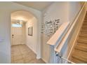 Entryway featuring tile flooring, archway to front door, and carpeted stairs with Gathering decor at 2816 Ivy Lake Ct, Lakeland, FL 33811