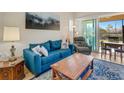 Cozy living room features a comfortable blue couch, a natural wood coffee table, and sliding glass doors to the lanai at 3019 Mission Lakes Dr, Lakeland, FL 33803