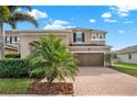 Charming two-story home featuring a brick driveway, a two-car garage, and well-maintained landscaping at 3460 Canvas St, Kissimmee, FL 34741