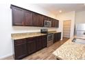 Stylish kitchen featuring granite countertops, stainless steel appliances, and wood-look floors at 4932 St James St, Winter Haven, FL 33881