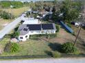 Aerial view of a home highlighting solar panels, well-kept lawn, and proximity to green spaces and neighborhood amenities at 495 King St, Haines City, FL 33844