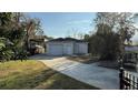 View of detached garage featuring a double garage door, white brickwork, and private driveway at 495 King St, Haines City, FL 33844