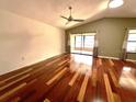 Spacious living room with vaulted ceilings, fan, and gleaming hardwood floors at 600 Caribbean Dr, Lakeland, FL 33803