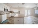 Bright kitchen featuring white cabinets, an island, stone countertops, and stainless steel appliances at 6011 Placid Pass, Lakeland, FL 33805
