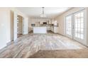 Bright, open kitchen boasts an island, stainless appliances, white cabinetry, and light wood-look flooring at 6011 Placid Pass, Lakeland, FL 33805