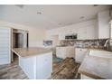 Bright kitchen with white cabinets, stone countertops, an island, and stainless steel appliances at 6011 Placid Pass, Lakeland, FL 33805